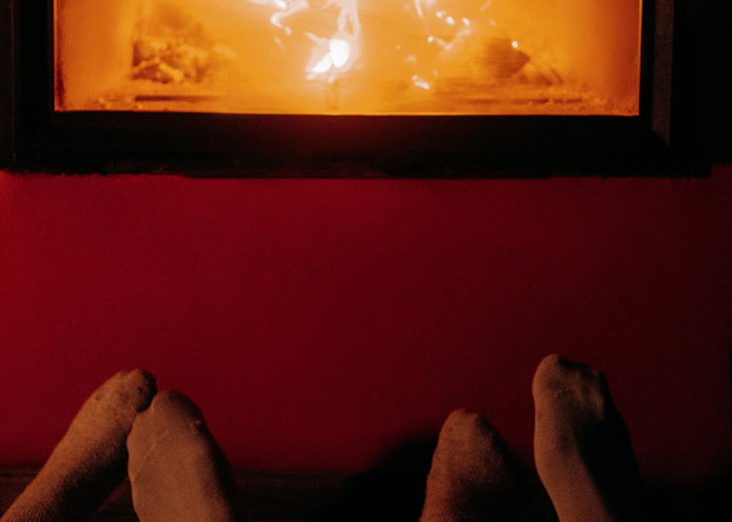 couple warming up their toes in front of furnace