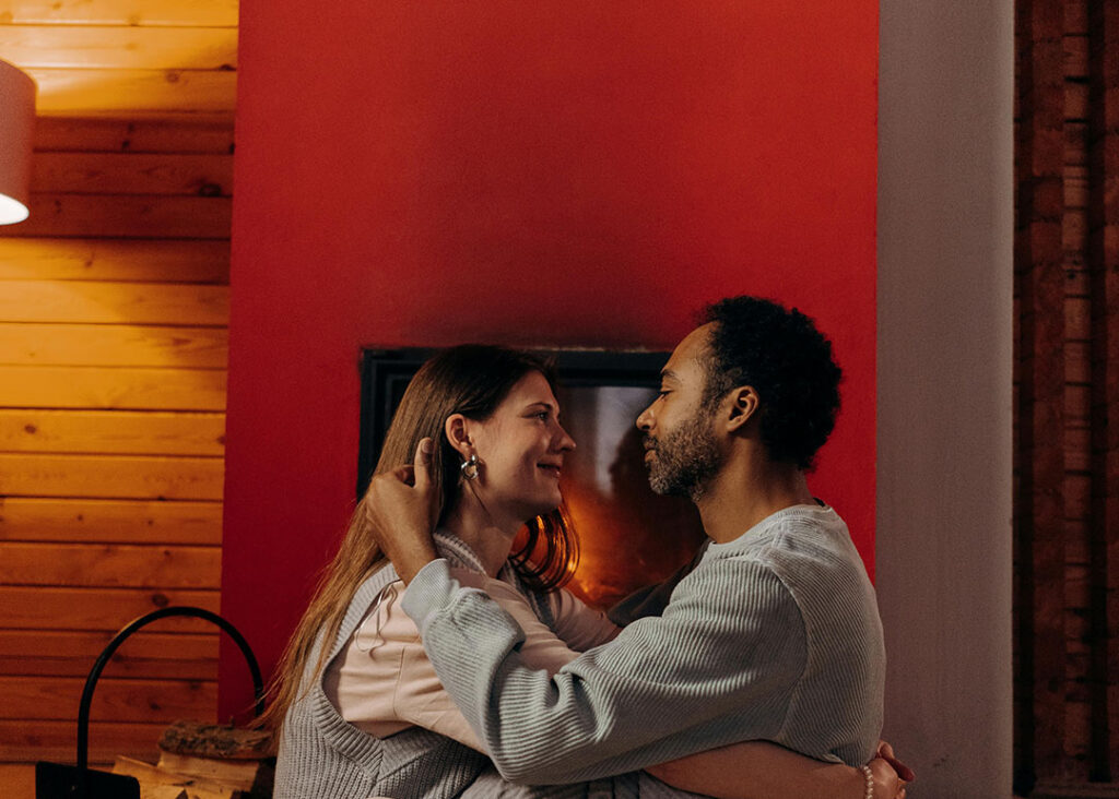 couple embracing in front of warm furnace